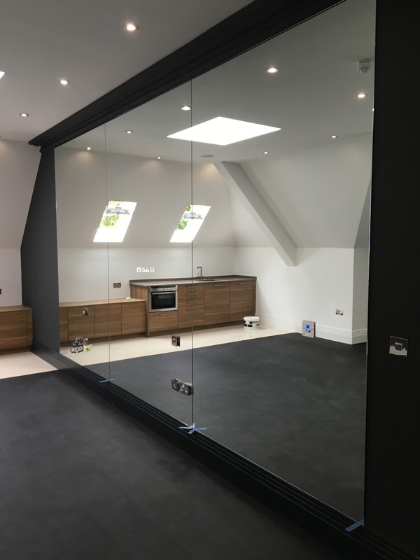 Frameless glass partition in loft conversion by Bletchley glaziers