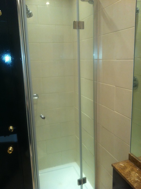Frameless glass shower enclosure with chrome fittings in Bletchley
