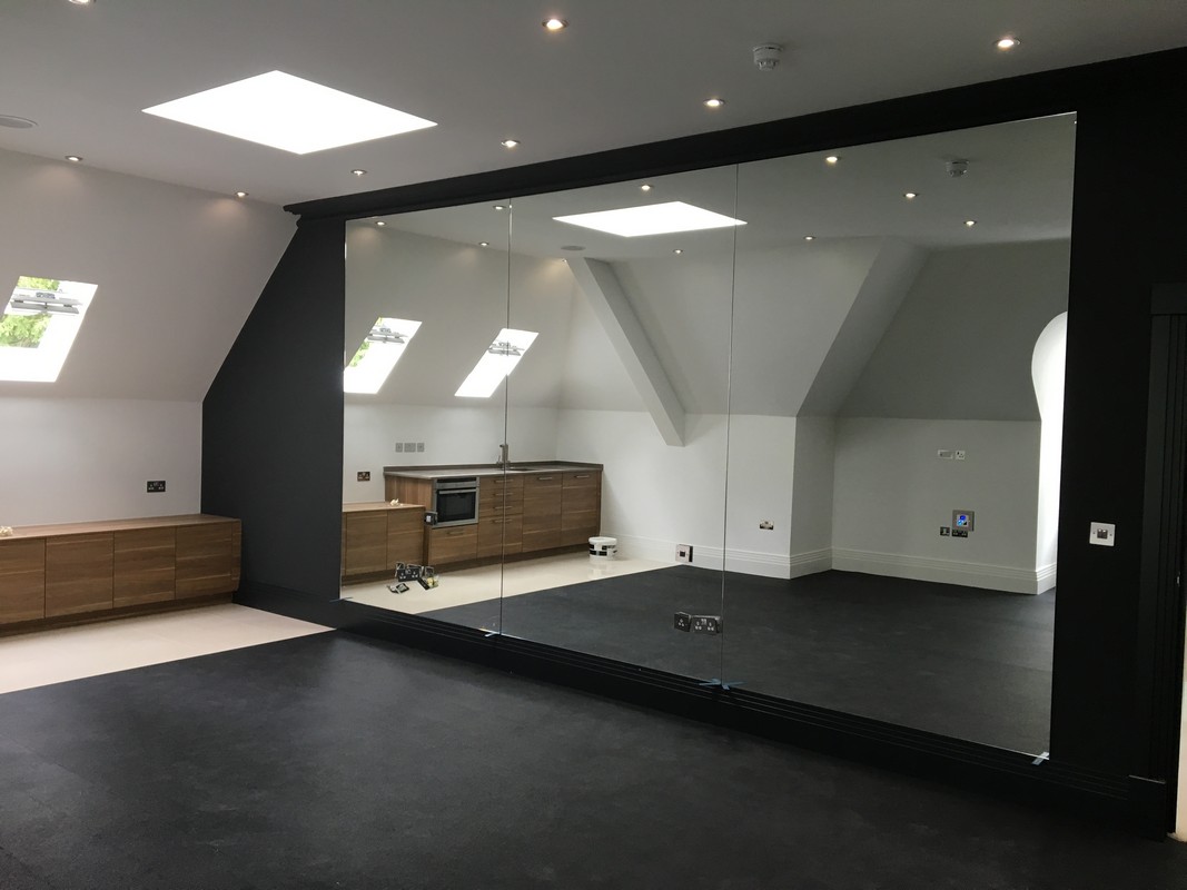 Frameless glass wall dividing loft conversion in Bletchley