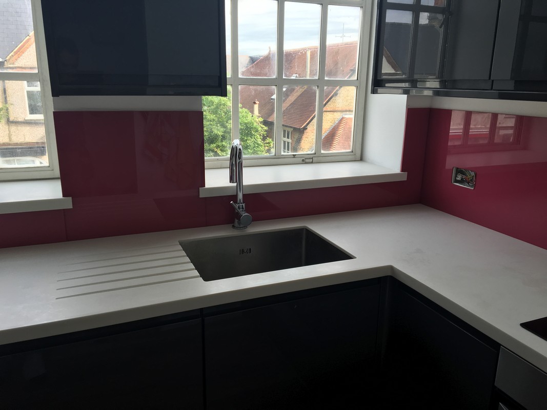 Deep plum coloured glass splashback in modern Bletchley kitchen